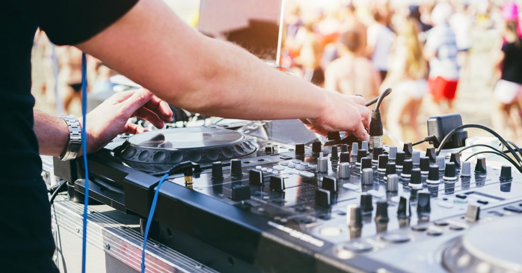 Dj pinchando en una playa.