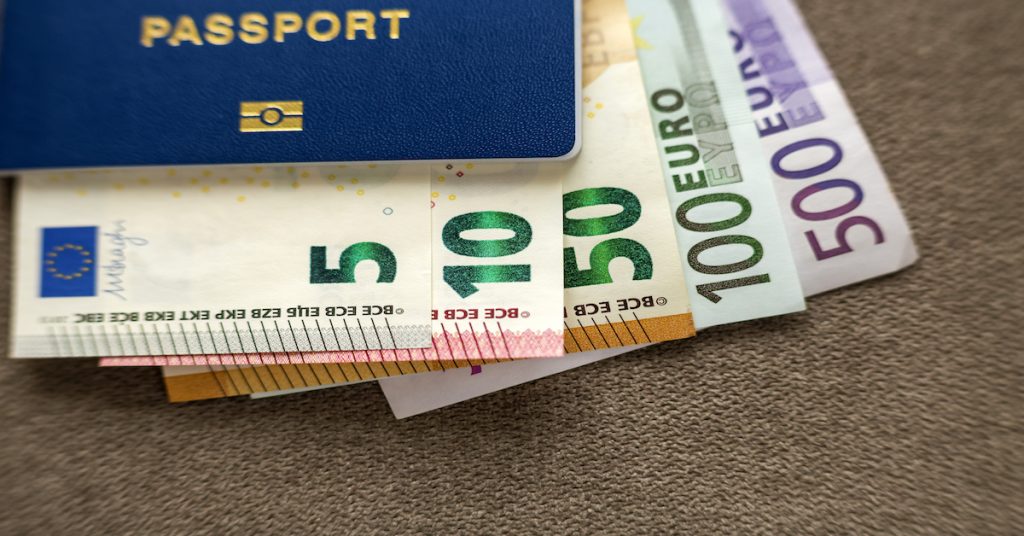 Detalle de pasaporte y varios billetes de cinco, diez, cincuenta, cien y quinientos euros
