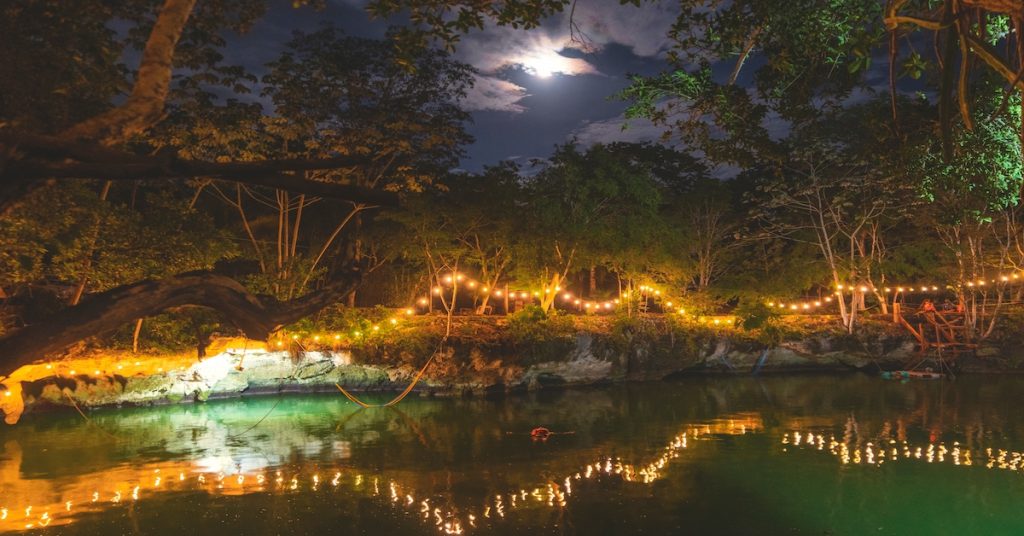 cenote con alumbrado nocturno en la Riviera Maya