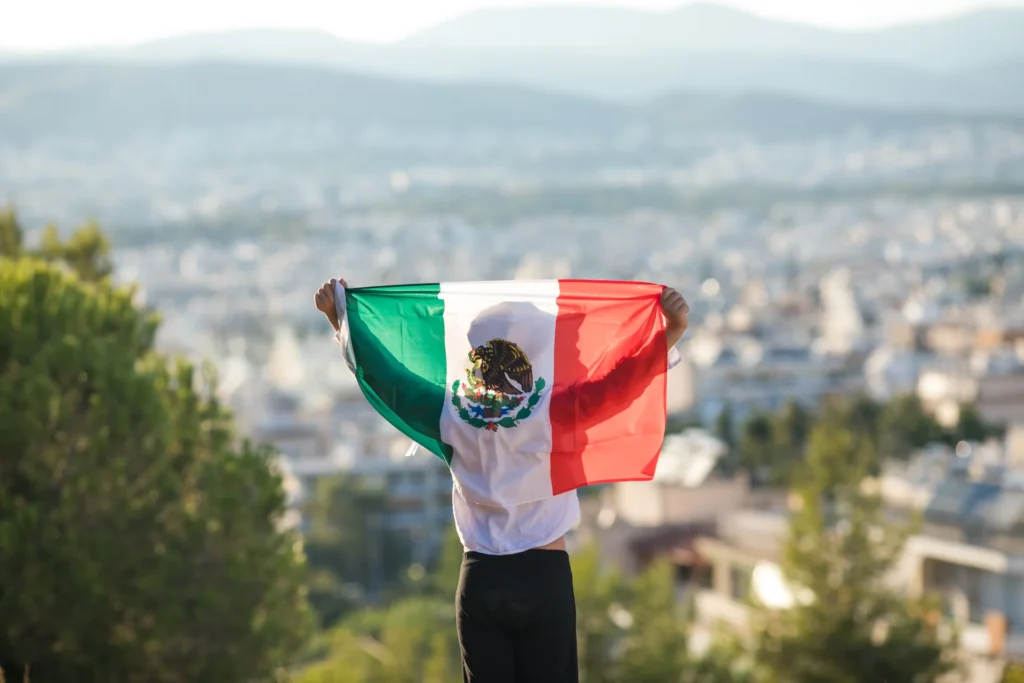Persona hondeando bandera mexicana.
