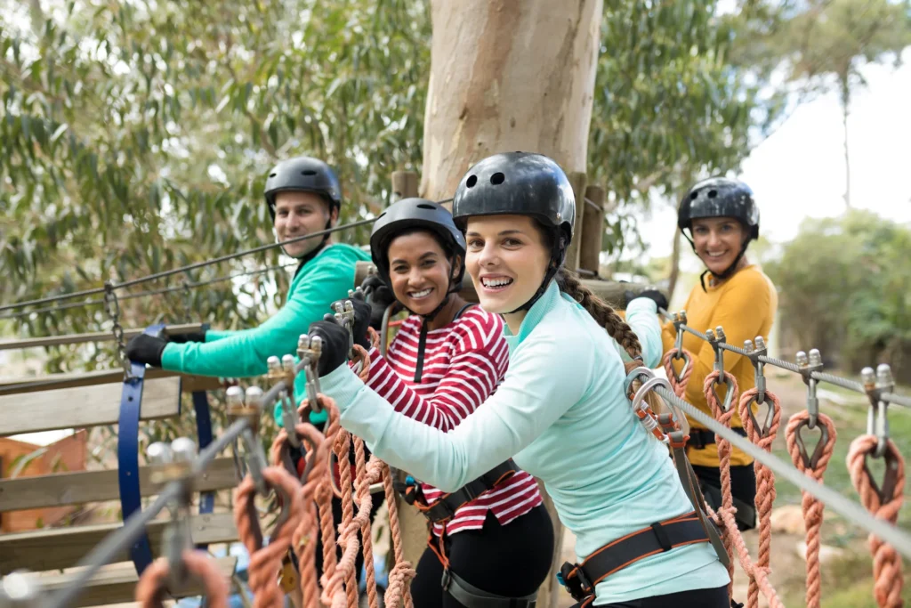 Amigas en puente para hacer actividades en parque de aventuras