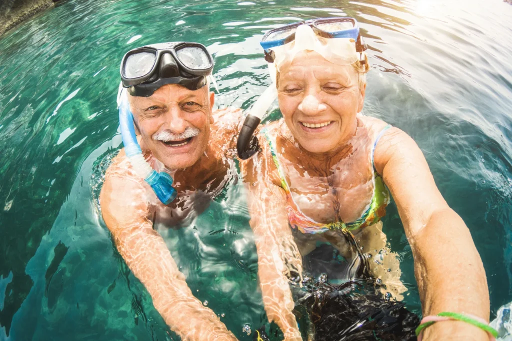 Pareja de jubilados haciéndose un selfie en el agua tropical