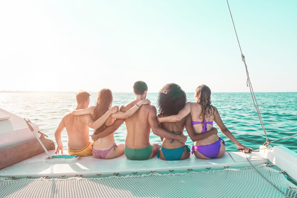 Grupo de amigos abrazándose con vistas al mar